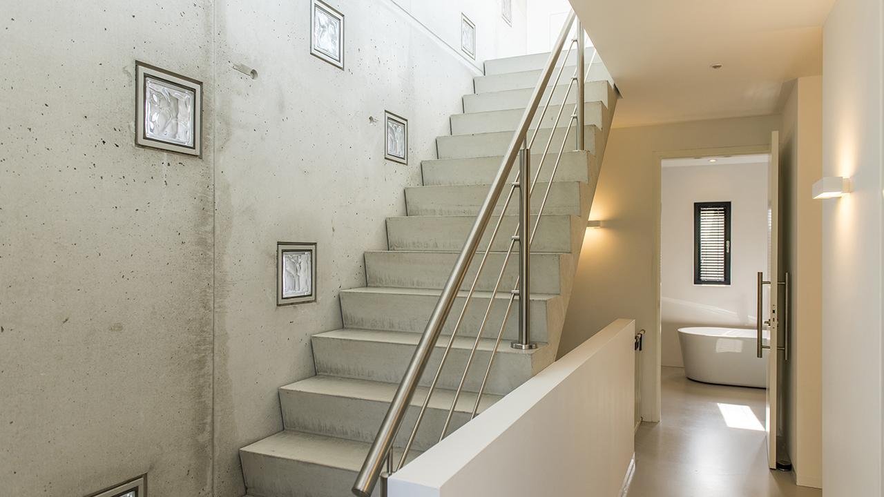De trap en wand zijn uitgevoerd in schoonwerk beton voor een stoer karakter